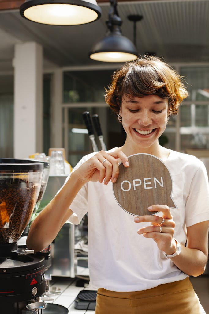 Woman standing in cafe with open sign